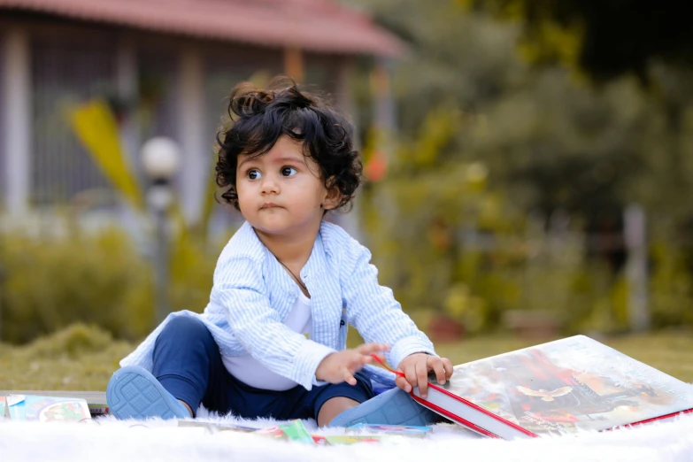 little girl sits on a floor reading a book