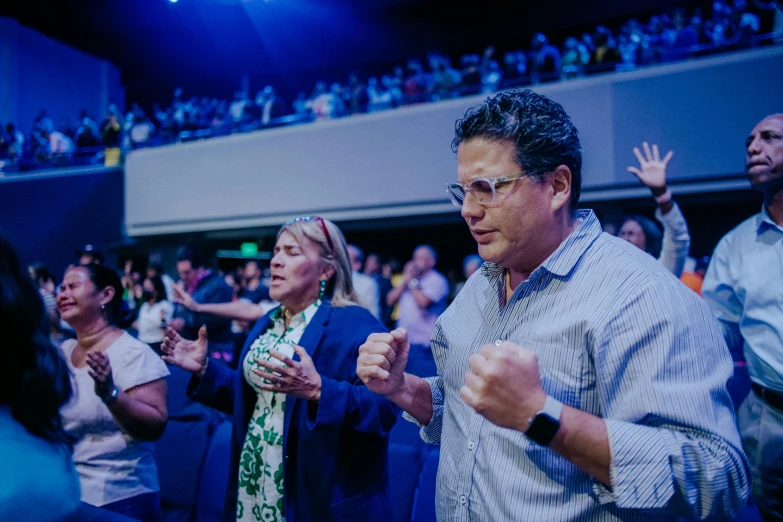 a group of people clapping and wearing blue jackets