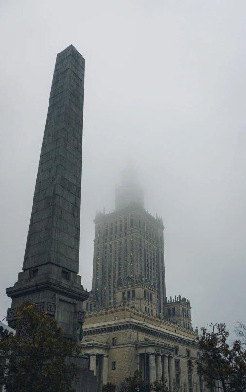 a big tower is sticking out of a foggy area