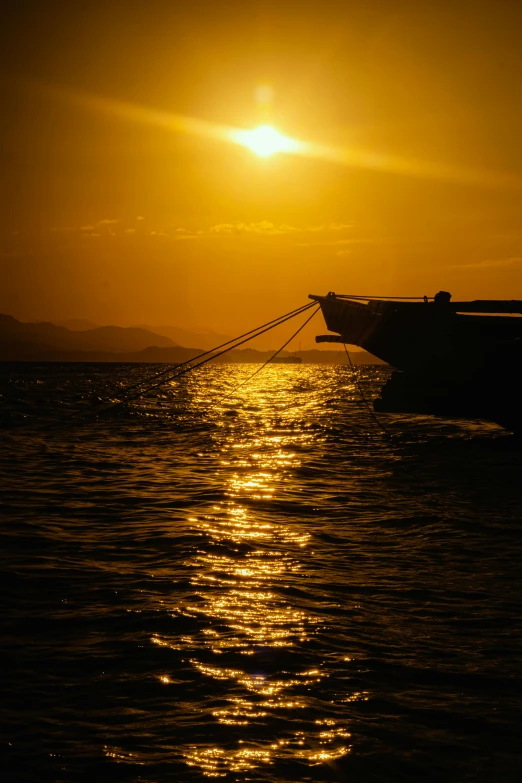 a boat is floating in the water as the sun sets