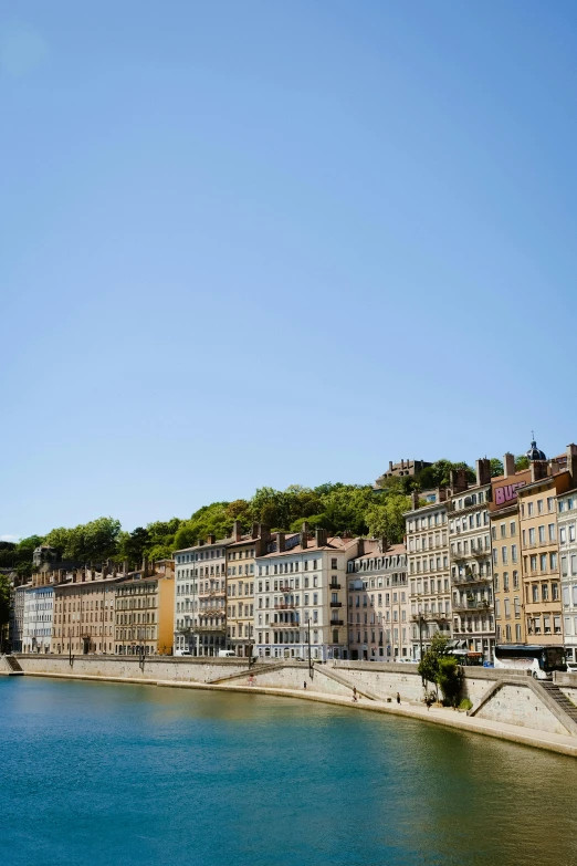 many buildings along a river with a hill on the top