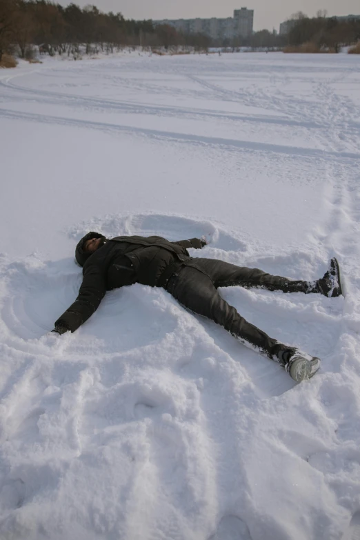 a person is laying in the snow with a ski pole nearby