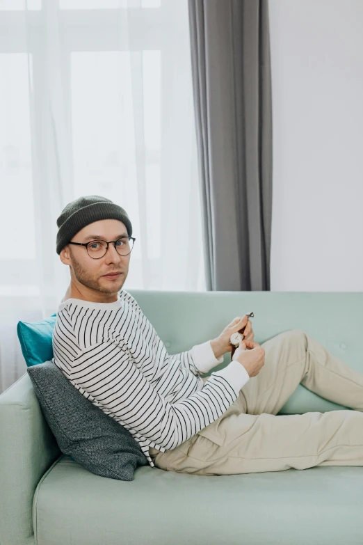 a man with glasses is sitting on a couch