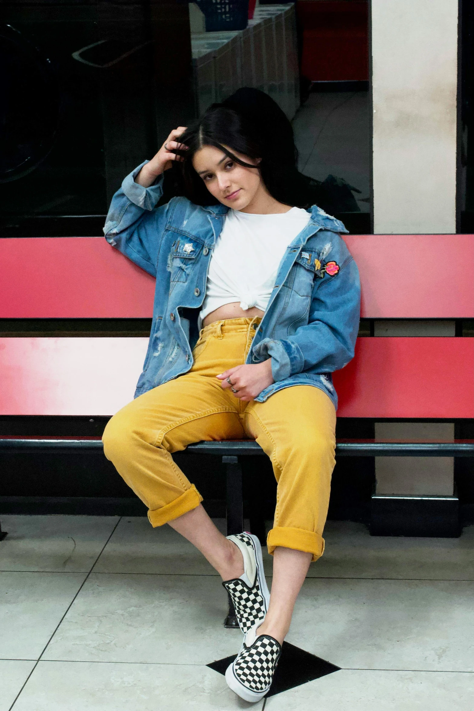 a woman in yellow and white is sitting on a bench