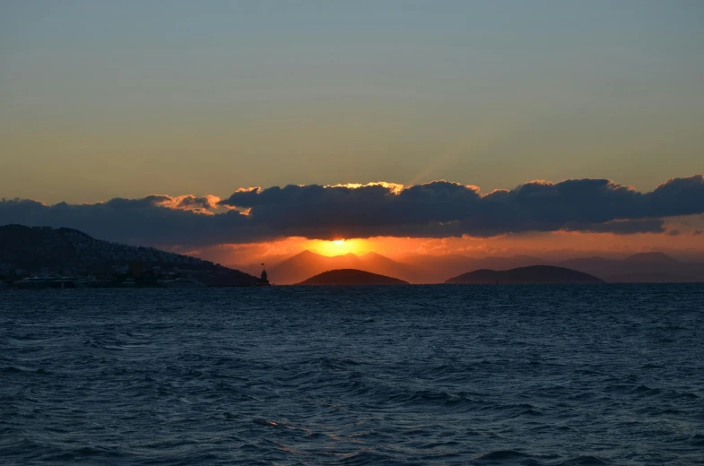 the setting sun reflects on a body of water