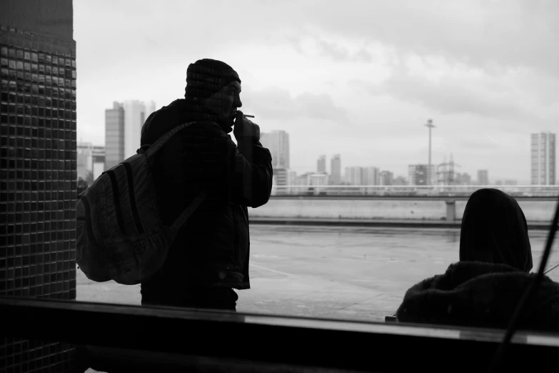 a man is standing outside and holding a cell phone to his ear