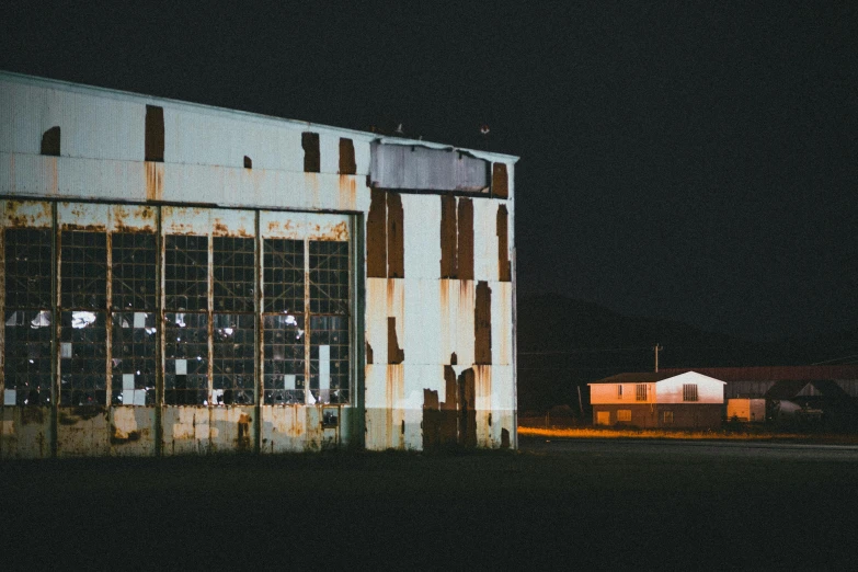 the silhouette of a building sits near a fence at night