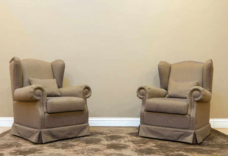 two brown recliners sitting on top of a carpet