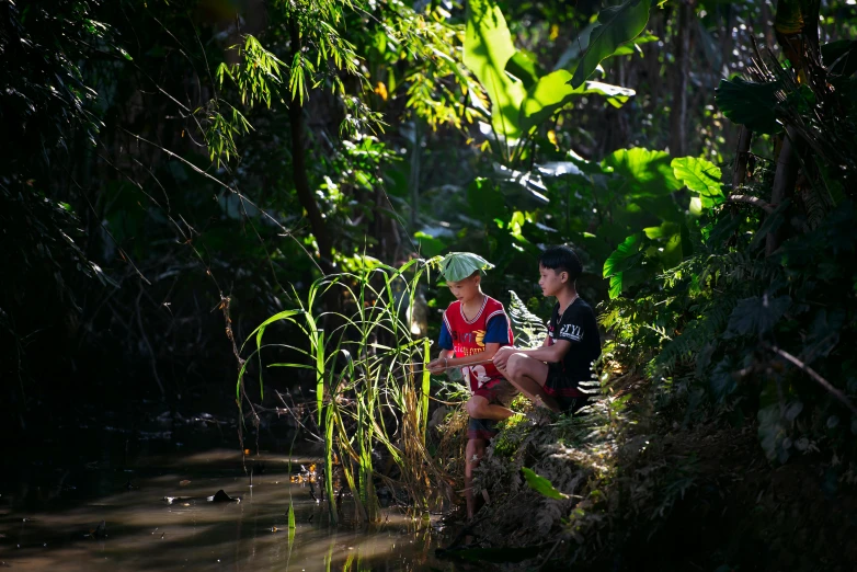 two people in a forested area with plants and a river