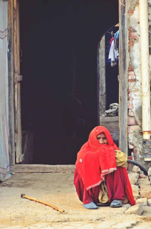 a woman sits in front of her house