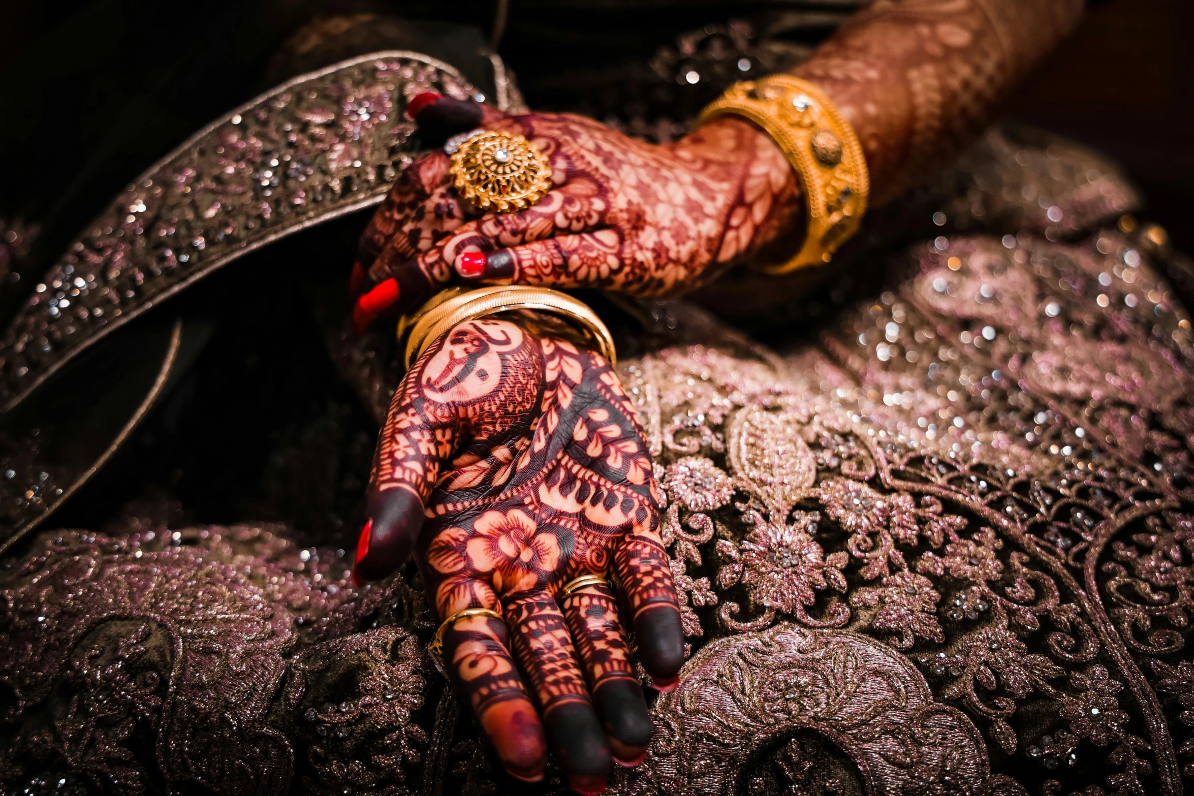 two hands are shown decorated with henna and gold jewelry