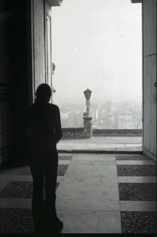 a person standing in an open doorway towards the city