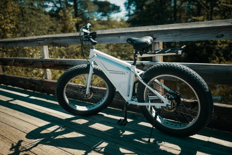 this bicycle is  to the side of a rail