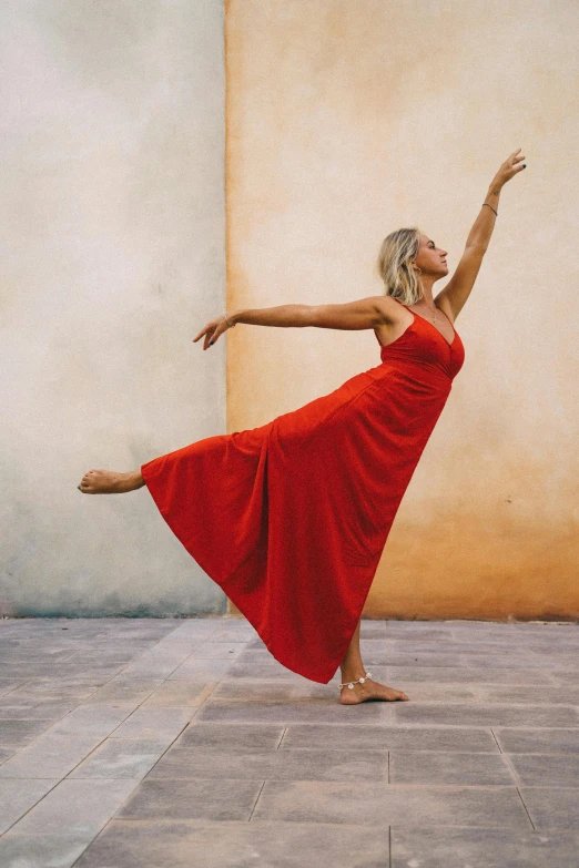 a woman in a red dress dances on a tiled floor