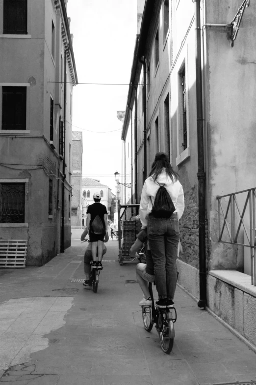 three people riding bicycles in the street