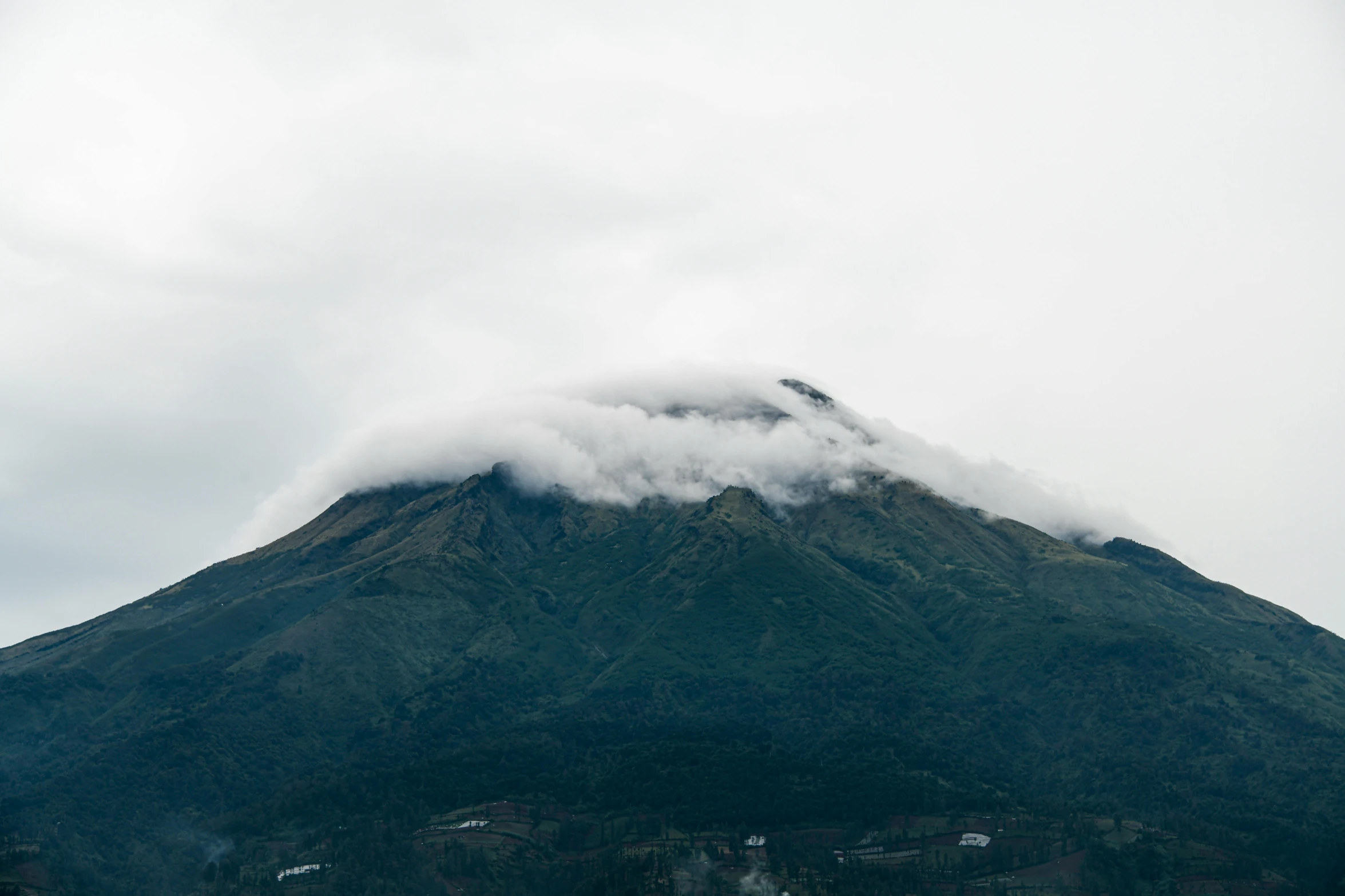 the clouds are billowing off the top of this mountain