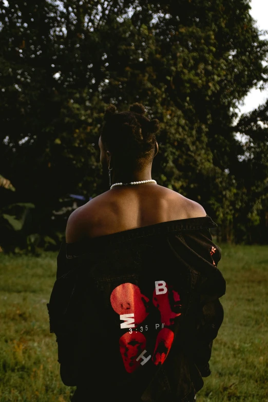 a woman in black is standing in the grass