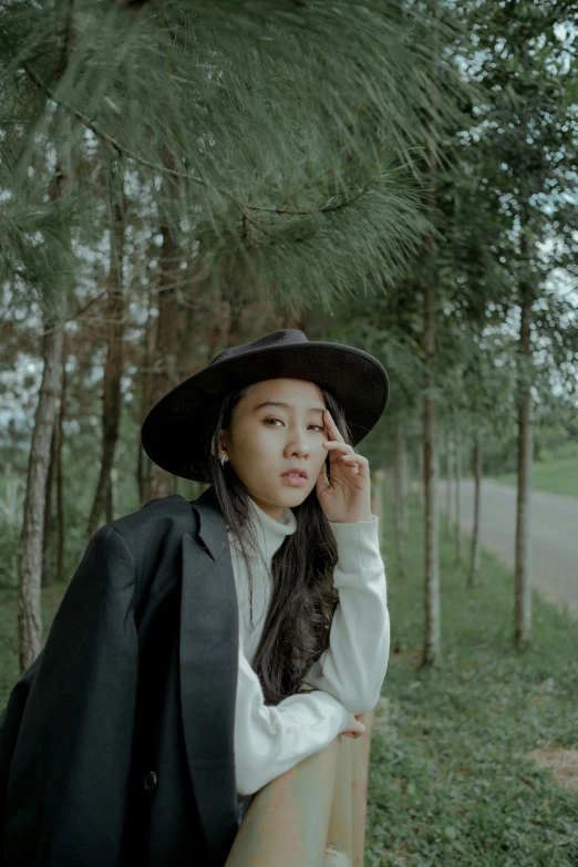 the woman is leaning against a rail in the woods