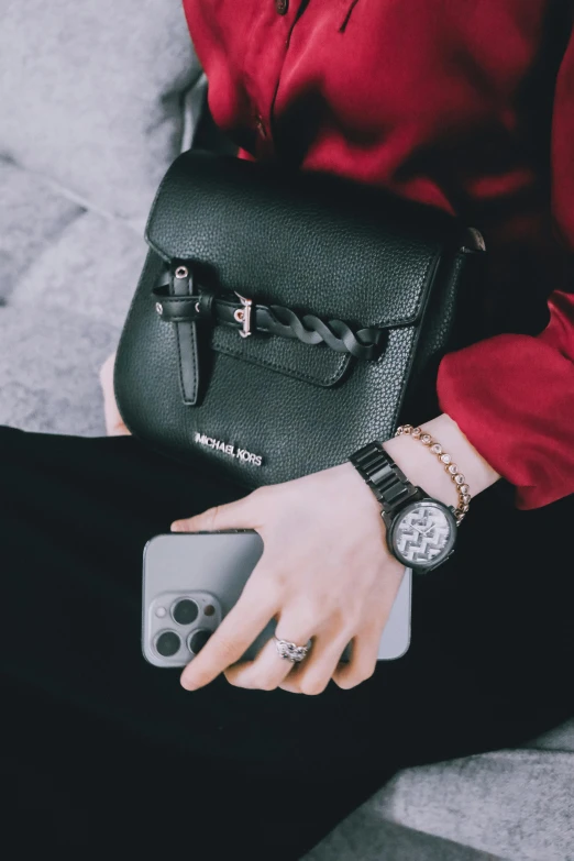 person holding a black watch and some wallets