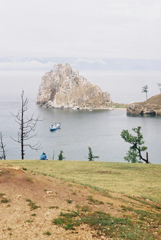 a man sitting on a bench looking out over water