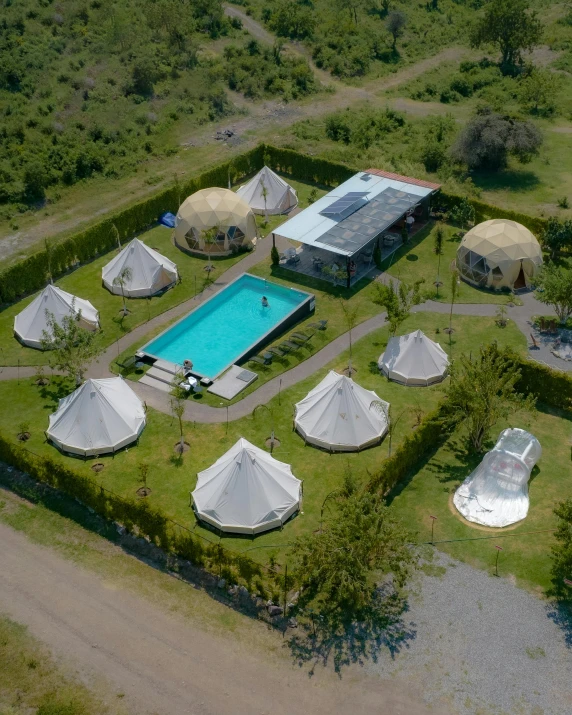 a field with tents and round houses