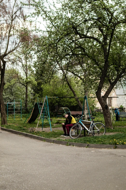 a person sitting in the grass next to a motorcycle