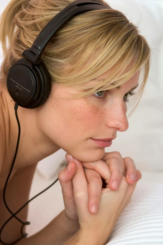 a woman wearing headphones laying on her stomach