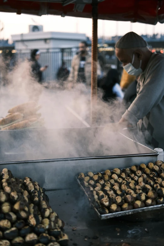 a person grilling chicken on a grill with smoke