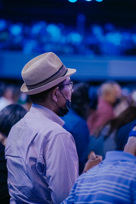 a man with glasses and a hat looks to the side