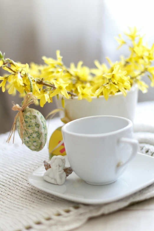 two cups with yellow flowers in them on a table