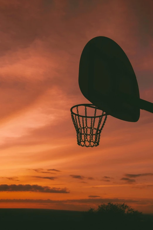 a basketball flying into the air at sunset