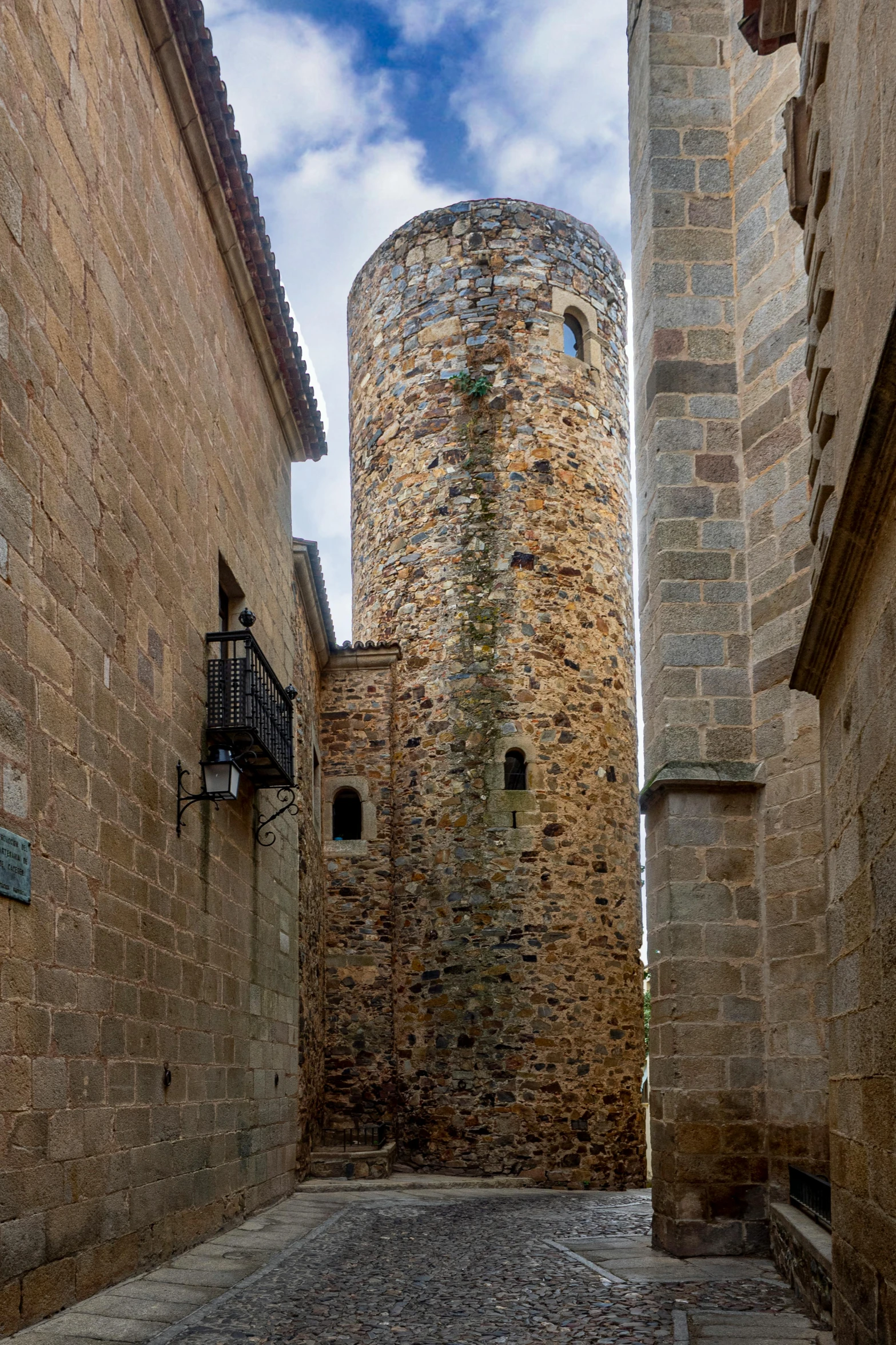 a stone building is standing tall in the middle of a brick alley