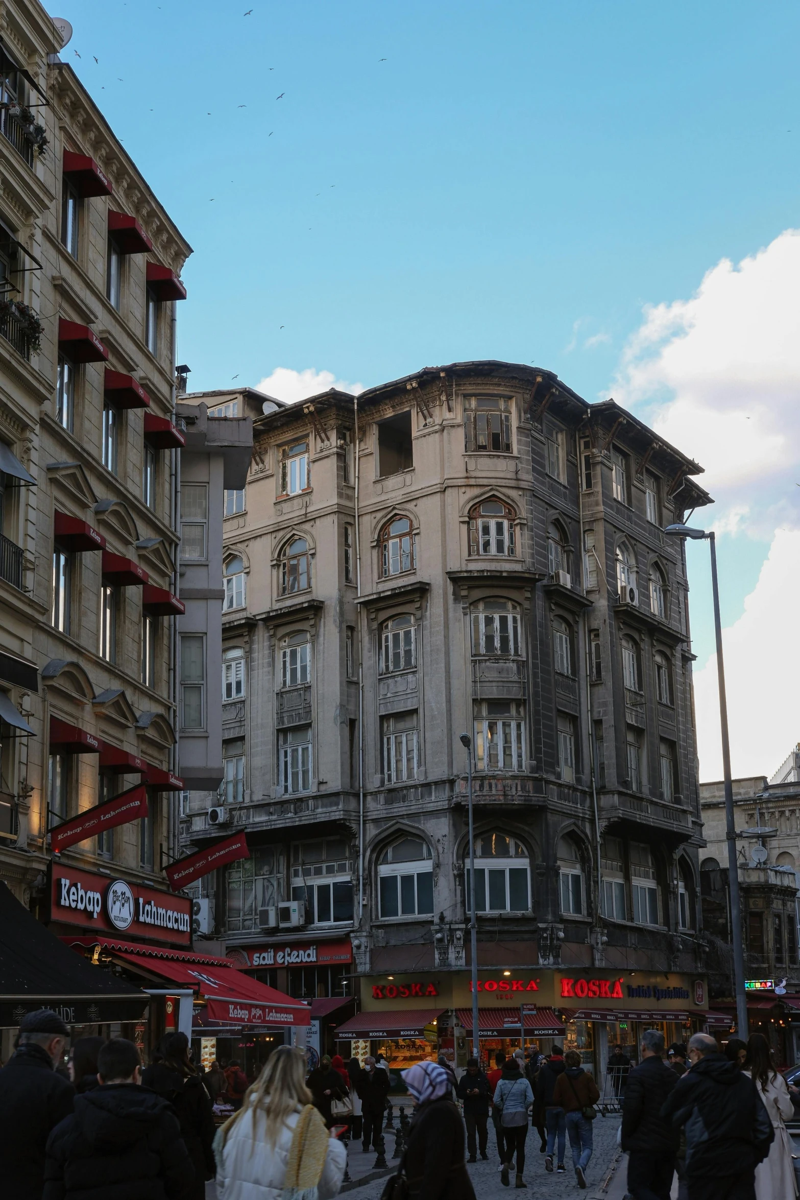 people are walking down a crowded street near a building