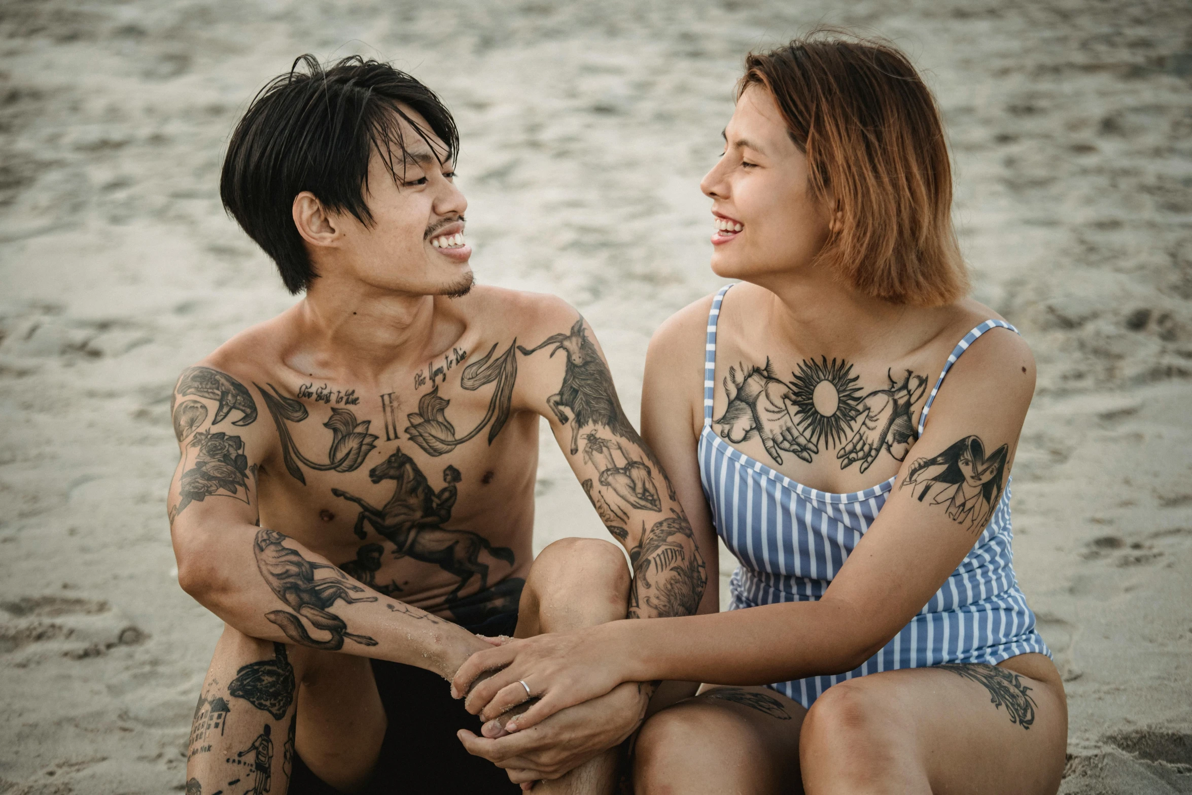 two people with tattoos on their body sitting together