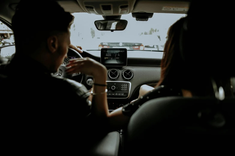 two people sitting in the back seat of a car