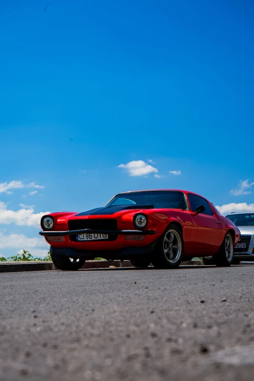 the red car is parked on the asphalt