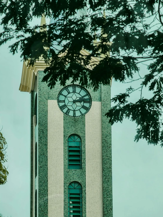 a tall clock tower with green shutters and a clock on the side of it