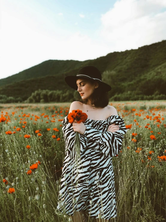 a girl with hat on a field of flowers