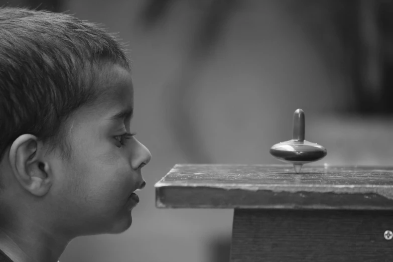 a child is sitting in front of a small object