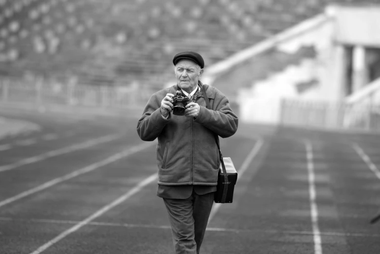 a man walking with his camera through the fog in the stadium