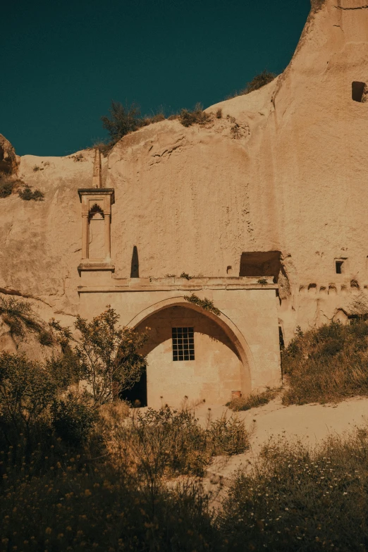 a cave structure sits on a desert hill