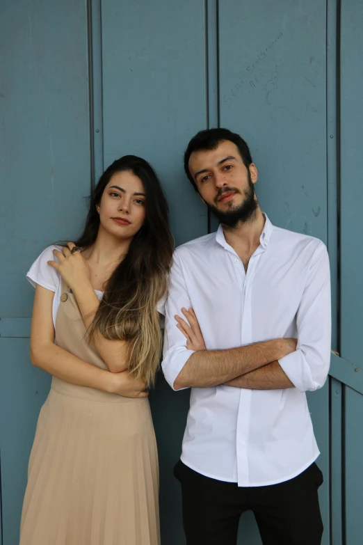 a couple posing with their arms crossed next to each other