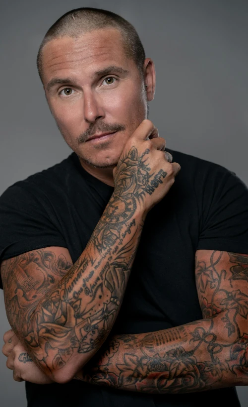 a man with tattoos on his arm and shoulders
