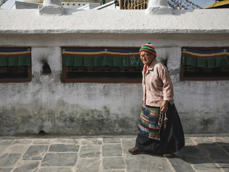 a person standing on the sidewalk near some building