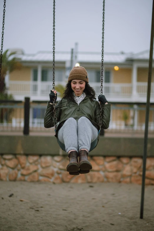 a person sitting in the swing at a playground