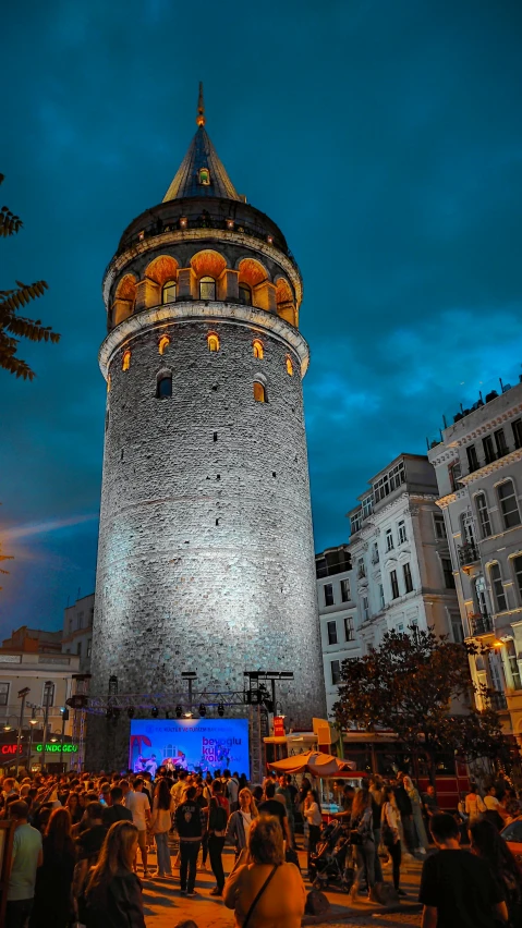 people gathered around a big tower at night