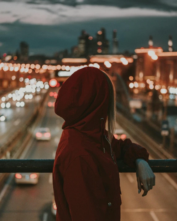 woman wearing red sweatshirt standing with cars on road