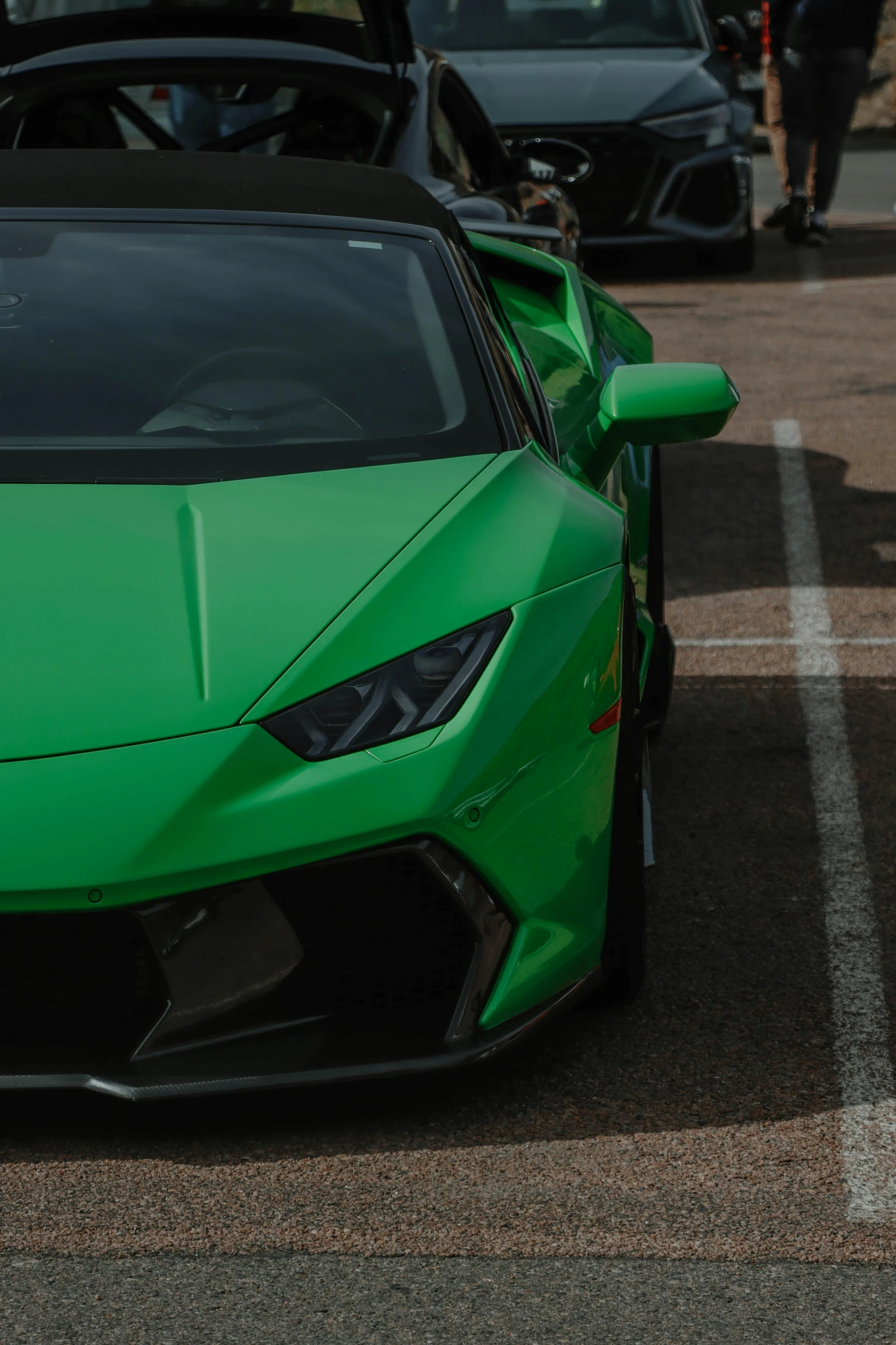 the green car is parked in the parking lot