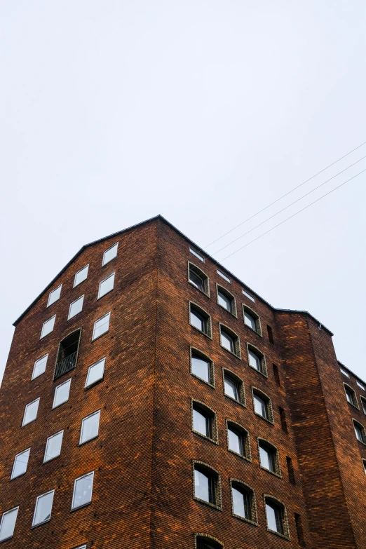 a brick building with some windows, and a plane in the air