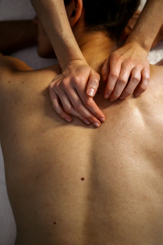 a person being massaged with their hands and body in a back position